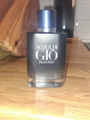 Acqua di Giò Profondo parfym - Acqua di Giò Profondo från Giorgio Armani är en elegant parfym i en mörkblå glasflaska med silverdetaljer. Flaskan har en stilren, matt finish och tydlig logga framtill. Doften är en Eau de Parfum och passar dig som gillar fräscha, marina toner.                                   