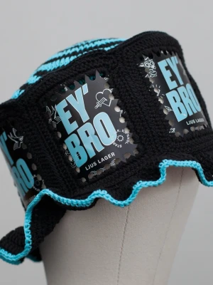 Virkad ölhatt Ey’bro - Unik virkad ölhatt med Ey’bro.   Virkad i 100% bomull. Passar upp till ca 60cm.  Vissa burkar kan ha mindre repor eller bucklor, vilket tyvärr kan uppstå under tillverkningen av hattarna. Insidan av burkarna slipas efter hålen tagits för att undvika vassa kanter. Därför kan det ibland finnas lite slipmärken, men det är inget som stör eftersom det är på insidan av hattarna.  Färger kan variera något beroende på skärminställningar.