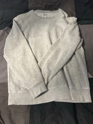 Ljusgrå sweatshirt  - En basic ljusgrå sweatshirt från H&M med rund halsringning och långa ärmar. Tröjan har en avslappnad passform och är tillverkad i mjuk bomullsmix, perfekt för en chill och enkel stil.