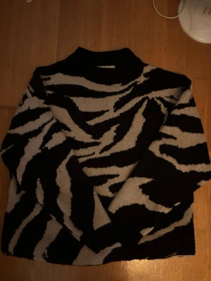 Stickad zebramönstrad tröja - Säljer en stickad tröja med svart och vit med en lite högre krage. Funkar från xs till m beroende på hur att man vill att den ska sitta
