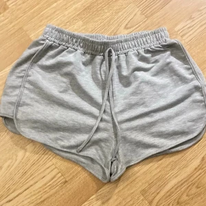 Gråa mjuka shorts med snörning - Säljer ett par bekväma gråa korta shorts i mjukt material med elastisk midja och snörning framtill. Dom är i storlek M och är endast testade. Säljes pga för små🤩☺️