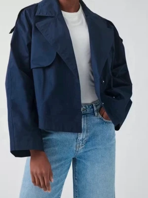Mörkblå cropped trenchcoat Gina Tricot - Stilren mörkblå cropped trenchcoat från Gina tricot med bred krage, stora slag och raka ärmar. Jackan har en boxig passform och är tillverkad i ett lätt tyg som ger en avslappnad look. Perfekt för lager på lager och trendiga outfits. Översized model!!!