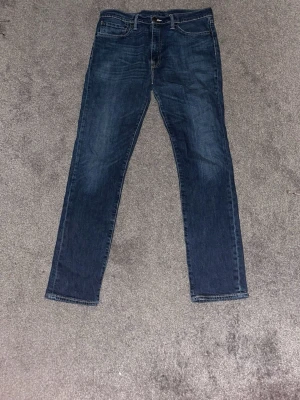 Mörkblå Levis 511 - Snygga mörkblå slim fit jeans med klassisk femficksdesign och lätt slitning på framsidan. Jeansen har normal midja och raka ben. Perfekta för en avslappnad och trendig look. W36(passar som 34)  L32
