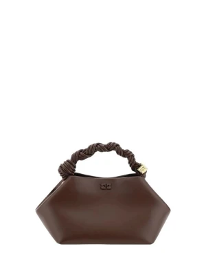 Ganni väska  - The Bou Mini Handbag i certifierat återvunnet läder från Ganni är en kompakt accessoar med en modern och distinkt design, definierad av sin ikoniska hexagonala silhuett. Den har en invändig magnetstängning och ett dubbelt invändigt fack med en ficka för praktisk och viktig organisering. Topphandtaget med vävd detalj förstärks av metalliska tärningsberlocker graverade med varumärkets logotyp, applicerade som ett signaturdekorativt element. Den avtagbara och justerbara platta axelremmen möjliggör 