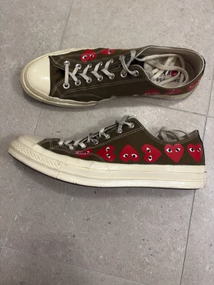 Converse x CDG Play olivgröna sneakers - Converse x Comme des Garçons Play sneakers i olivgrönt canvasmaterial med vita sulor och tåhättor. 