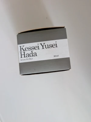Kessei Yusei Hada serum 30 ml - Säljer ett serum för fet hud från Kessei Yusei Hada. Produkten kommer i en stilren, grå rund burk med vit etikett och rymmer 30 ml. Perfekt för dig som vill balansera och vårda huden med ett exklusivt serum.