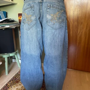 baggy jeans - marinblå baggy jeans med feta fickor och rosa sömmar! byxorna är insydda i midjan och upptagna i längd av skräddare.