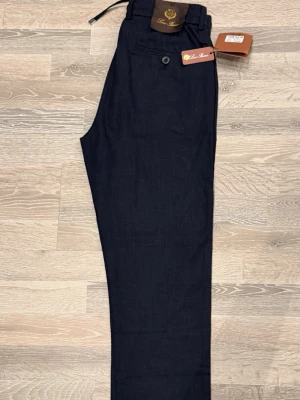 Marin blåa linnebyxor raka ben - Marin blåa linnebyxor med raka ben och enkel design. Byxorna har en klassisk passform och är tillverkade i svalt linnematerial, perfekta för en stilren och avslappnad look.