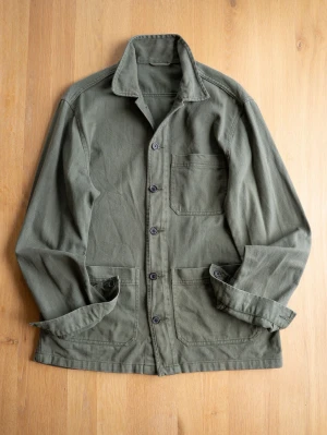 Olivgrön overshirt med fickor - Stilren olivgrön overshirt i kraftigt bomullstyg med tre utanpåliggande fickor och knäppning framtill. Klassisk krage och raka ärmar med knapp vid manschetten. Perfekt lager på lager-plagg för en avslappnad look.