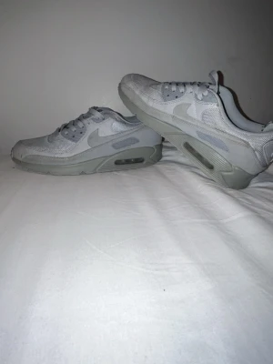 Grå Nike Air Max 90  - Säljer ett par stilrena grå Nike Air Max 90 sneakers med klassisk siluett. Skorna har mesh- och läderdetaljer. Ganska använda. Behöver ba tvättas och nya sulor sen är de perfekta! Pris kan diskuteras 