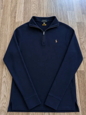 Ralph Lauren 1/4 zip - Tjena, jag säljer en riktigt snygg Ralph Lauren zip hoodie😄 Den är i mycket bra skick och har inga fläckar eller skador☺️ Den är självklart äkta✅ Skicka om du har några frågor 😁