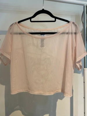 Rosa T-shirt - En rosa genomskinlig T-shirt från Decathlon, storlek S. Använd en gång.