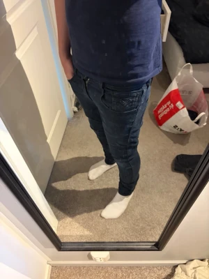 Replay anbass jeans w29 l32 - Snygga mörkblå slim fit jeans från Replay med klassisk femficksdesign och svarta detaljer på bakfickan. Jeansen har normal midja och är tillverkade i stretchigt denimtyg för extra komfort. Perfekta för en trendig och avslappnad stil.