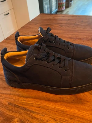 Mörkblå sneakers med röd sula - Snygga mörkblå loubs som är lite slitna. Dom är ändå jättesnygga. Där storleken står har slitits bort men jag har mätt och det är storlek 39 men är stor i storleken så kan passa srl 40.
