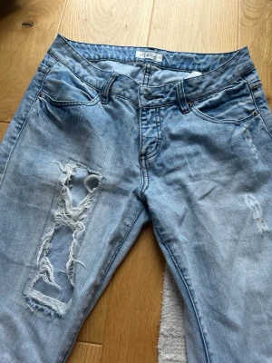 Snygga baggy jeans med slitningar - Säljer ett par ljusblå, baggy, lågmidjade jeans med coola slitningar. Aldrig använda då de ej passade mig. Pris kan diskuteras🩷