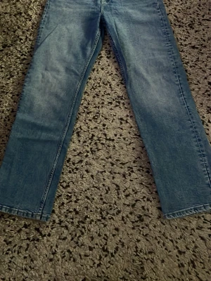 Blå raka jeans - Säljer ett par blå straight jeans med mid/hög midja. 