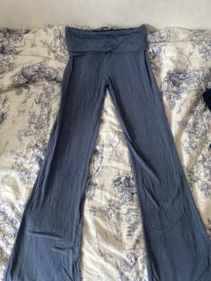 Mörkblå yogapants - Mörkblå yogabyxor med vikbar midja och utsvängda ben. Har tyvärr fått en fläck som inte går bort i tvättmaskinen.