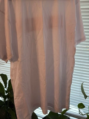 Vit t-shirt med röd GASTRINO-logga - Vit t-shirt med klassisk passform och korta ärmar. På ryggen finns en stor röd rektangel med texten GASTRINO i vitt. T-shirten är i bomull och har en enkel, stilren look som passar till det mesta.