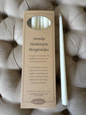 Svenska handstöpta herrgårdsljus - Säljer en förpackning med vita handstöpta herrgårdsljus från Svenska Herrgårdsljus. Ljusen är tillverkade av stearin och paraffin med bomullsveke, och har en klassisk avlång form. Perfekta för mysiga kvällar eller som dekoration hemma. Endast öppnare för fotografering🫶