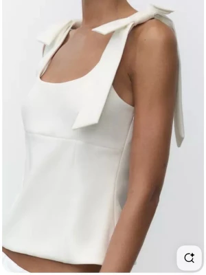 Vit linnetopp med rosetter från Zara - Köpte en linnetopo med rosetter på axlarna från Zara. Den kommer inte till användning och har använt den en gång.