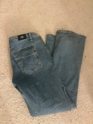 Blå ltb jeans  - Säljer ett par klassiska blå jeans från LTB med rak passform och femficksdesign. Jeansen har en snygg ljus tvätt och detaljerade sömmar på bakfickan. Perfekta till vardagslooken och tillverkade i mjuk denim.