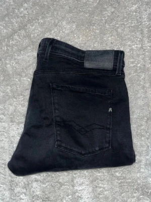Replay Anbass jeans - Svarta Replay Anbass Jeans. Midja 48cm, längd 103cm. JAG SKICKAR EJ FLER BILDER NÄR JAG BÄR JEANSEN! för bättre inblick i passformen rekommenderar jag att googla på modellnamnet. För storleksguide kolla måtten noggrant då jeansen alltid kan vara uppsydda heller krympta och jag ej tar emot returer :) 1,51
