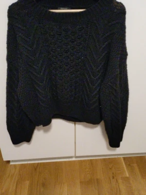 Svart chunky stickad tröja - Mysig svart stickad tröja med grovt mönster och breda ärmar. Tröjan har rund halsringning och ribbade muddar vid ärmslut och nederkant. Perfekt för kalla dagar och enkel att styla till olika outfits. Kommer inte ihåg vart den är ifrån men märket är Esmara! Den är cirka 42cm lång. Pris går alltid att diskutera.  Storlek M 40-42