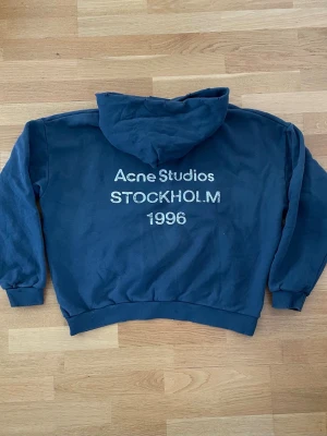 Acne Studio Hoodie - Säljer denna ursnygga mörkblåa acne studio hoodie i storlek M. Hoodien är endast använd vid några få tillfällen men är fortfarande i nyskick. Kvitto finns, hör av dig vid frågor eller liknande.