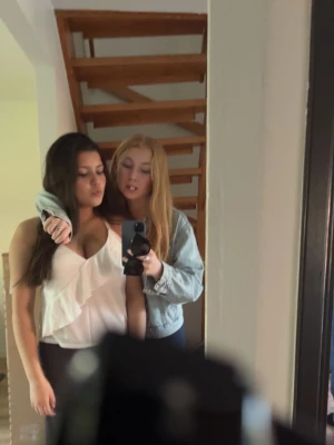 Vit omlott volangtop - Säljer en vit omlott topp med volangdetaljer. Toppen är ärmlös och har en djup v-ringning. Perfekt för dig som vill ha något stilrent och fräscht till garderoben💗