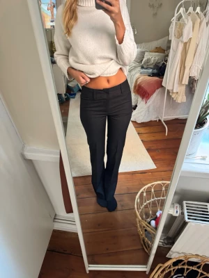 Svarta kostymbyxor med raka ben - Säljer ett par svarta kostymbyxor med raka ben och låg midja. Byxorna har diskreta fickor fram och bak, samt pressveck för en clean look. Perfekta till en snygg stickad tröja eller skjorta. Materialet är ett aning stickigt. De finns även små små linjer på byxornas mönster 💟