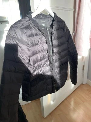 Svart dunjacka från Zara Woman - Snygg svart dunjacka från Zara Woman med dragkedja framtill och diskreta fickor. Jackan har en klassisk quiltad design och är lätt vadderad, perfekt vårjacka!!