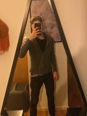 Grå ziptröja med hög krage från These Glory Days - Säljer en enkel och stilren grå ziptröja med hög krage och långa ärmar. Tröjan har dragkedja framtill och ribbade muddar vid ärmslut och nederkant. Perfekt att slänga på sig när det är lite kyligt. Säljer denna då den är alldeles för liten men riktigt snygg tröja av merinoull. Nypris 1099kr säljer för 400kr