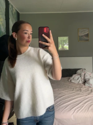 Vit stickad t-shirt från Gina tricot  - En enkel och stilren vit stickad t-shirt med rund hals och korta, vida ärmar. Tröjan är köpt från Gina tricot. I använt skick. 