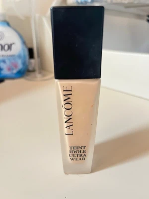 Lancôme Teint Idole Ultra Wear 235N - Foundation från Lancôme i nyansen 235N. Kommer i en stilren glasflaska med svart lock och har SPF 35. Ger naturlig täckning och håller upp till 24 timmar. Innehåller 30 ml och är parfymfri samt testad under dermatologisk kontroll.