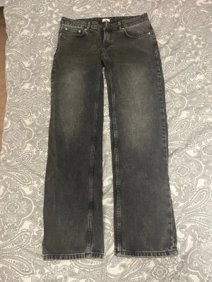 Grå raka jeans med vintagekänsla - Säljer ett par grå jeans med rak passform och klassisk femficksdesign. Jeansen har en tvättad vintage-look och normal midja. Perfekta för en avslappnad och trendig stil. Materialet är denim i bomull. Passar dig som gillar en enkel men snygg look.