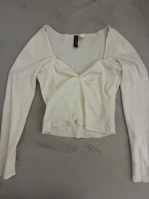 Vit ribbad långärmad topp från Divided - Snygg vit ribbad topp från Divided med lång ärm och v-ringad hals.