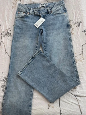 Ljusblå raka jeans från 157 - Ljusblå jeans med rak passform från 157. Klassisk femficksmodell med bälteshällor och knappgylf. Jeansen har en avslappnad look och är tillverkade i denim. Perfekta för en trendig och enkel stil.
