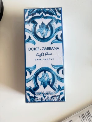 Dolce & Gabbana Light Blue Capri - Köpte den i kicks för 966kr på rea ( original pris 1380) men kan sälja den för 750kr köpte denna parfym till min vän som födelsedags present, tyvärr blev det aldrig av, så jag säljer den här istället då citrus parfymer inte är min smak🥲  parfymen är helt oöppnad som ni ser( har fortfarande plasten kvar) kan ej returnera till butik  pågrund av att ja köpte den 3 juni och retur/ ångerrätten har passerat. Därför säljer jag den här på plick