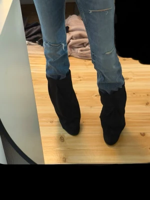 Snygga svarta ikoniska y2k boots med klack - Säljer ett par fina svarta ikoniska vintage y2k boots med klack i storlek 38. Klacken är ungefär 5-6 cm hög. Aldrig använt. Har sytt och fixat med de själv. 