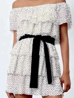 Vit prickig offshoulder klänning - Söt kort offshoulder klänning ifrån Zara. Klänningen har ett svart band som man knyter i midjan som går att klippa bort om man vill det❤️ storlek S men passar även M🥰