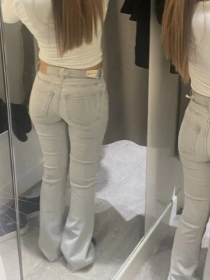 Gina tricot bootcut jeans - Säljer ett par ljusgrå bootcut jeans . Jeansen är mid-low waist och är tillverkade i ett mjukt denimtyg. Perfekta för en avslappnad och stilren look.