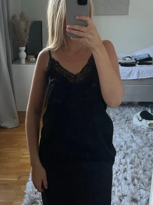 Svart satin klänning med spetsdetaljer - Svart satin nattlinne/klänning från H&M. Otrolig med en stickad tröja eller kavaj över. Storlek Xs