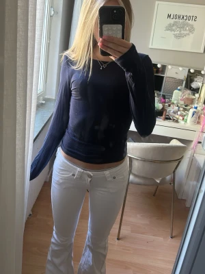 Mörkblå långärmad topp - Snygg mörkblå långärmad topp med rund halsringning. Modellen är tight och enkel, perfekt att matcha med olika stilar. Materialet ser ut att vara mjukt och stretchigt, vilket ger en bekväm passform.