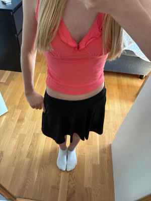 Svart kortkjol med under shorts  - En svart kortkjol med utsvängd passform och bred linning. Kjolen har en enkel och stilren design som passar till många olika outfits. Materialet känns mjukt och följsamt, perfekt för dig som gillar en bekväm men snygg look. De har inbyggda fickor och shorts, De är från SHEIN,på lappen står de att de är för 10 år men passar även för äldre. Köpt för 129kr, säljer för 40kr