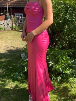 Rosa balklänning med öppen rygg - Säljer min fina rosa balklänning från Nelly, med tunna axelband och öppen rygg. Klänningen är uppsydd hos skräddare, (jag är 166cm lång).  Klänningen är använd 1 gång.
