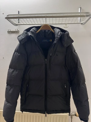 Polo Ralph Lauren Jacka - Polo Ralph Lauren dunjacka i färgen grå. Varm jacka med huva. I gott skick. Storlek: XS men passar även för S.                                        Kvitto finns också!