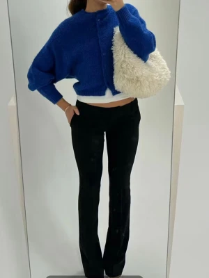 Svarta flare kostymbyxor - Säljer ett par svarta kostymbyxor som har flare passform och låg midja. Byxorna har en klassisk look och är perfekta för en clean och stilren outfit. Materialet ser ut att vara mjukt och följsamt, vilket ger en snygg siluett.