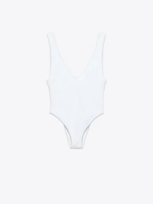 BADDRÄKT MED SKRYNKLIG EFFEKT - Säljer en stilren vit baddräkt med djup rygg och breda axelband. Modellen har en enkel och tidlös design med V-ringning framtill. Materialet är stretchigt och bekvämt för en snygg passform.