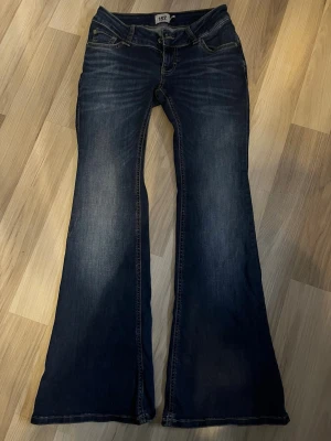 Mörkblå low waist jeans 157 - Snygga mörkblå bootcut jeans från lager  157 med klassisk femficksmodell och låg midja. Jeansen är väldigt lågmidjade och är i modellen blaze. De är använda kanske en gång