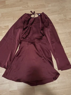 NA-KD klänning, strl 40 (38) - Satinklänning/festklänning med öppen rygg från NA-KD. Artikelnummer hos NA-KD för att se modell: 1017-002210-0362  Strl 40 men passar mig som vanligtvis har strl 38. Nypris 699 kr. 